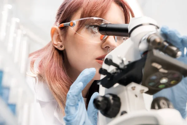 Scientifique regardant à travers le microscope — Photo de stock