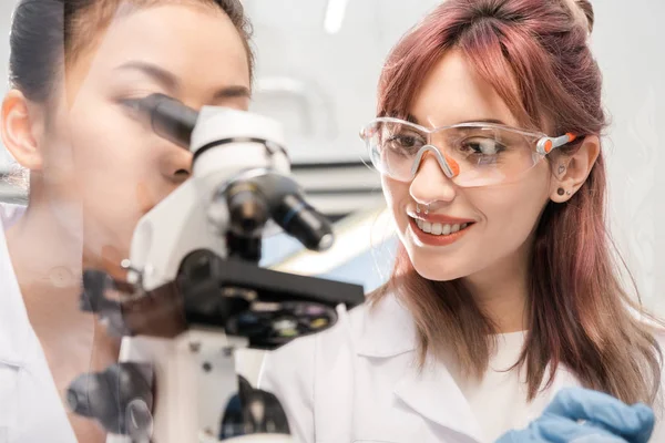 Scientifique regardant à travers le microscope — Photo de stock