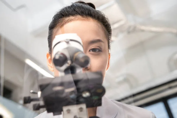 Scientifique regardant à travers le microscope — Photo de stock