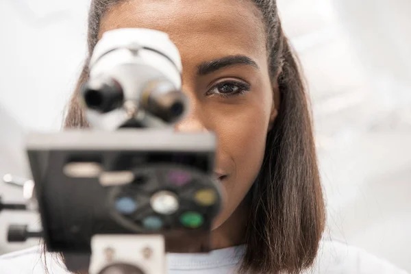 Scientist looking through microscope — Stock Photo