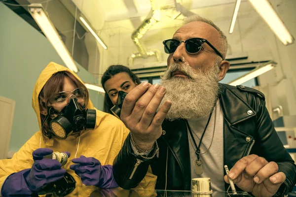 Man taking drugs with women in equipment — Stock Photo