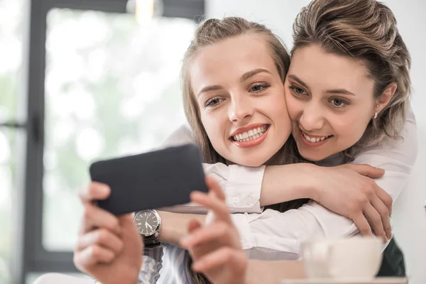 Novias sonrientes tomando selfie en el teléfono inteligente — Stock Photo