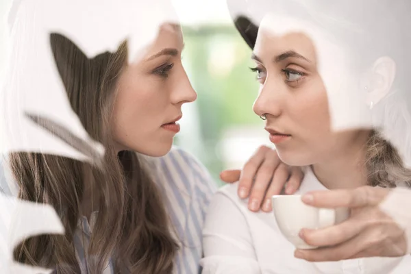 Young sensual girlfriends drinking coffee — Stock Photo