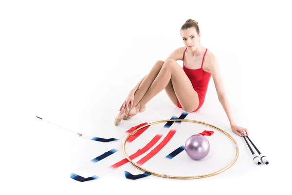 Girl sitting near rhythmic gymnastics apparatus — Stock Photo