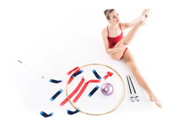 Girl stretching near rhythmic gymnastics apparatus — Stock Photo