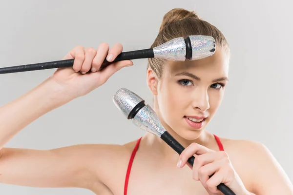 Caucasian woman rhythmic gymnast with clubs — Stock Photo