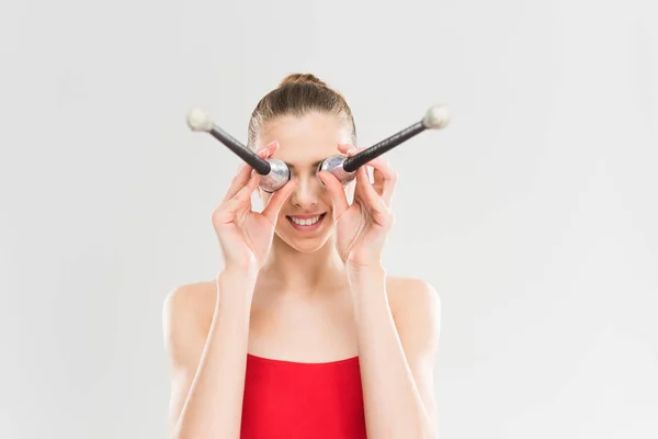 Woman rhythmic gymnast holding clubs — Stock Photo