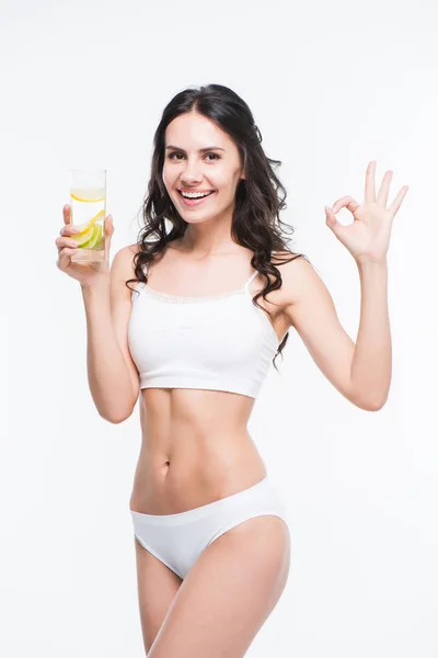 Женщина держит стакан воды с лимоном — стоковое фото