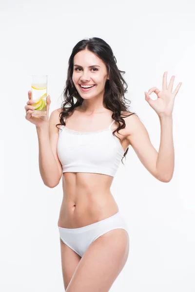 Donna che tiene un bicchiere d'acqua con limone — Foto stock