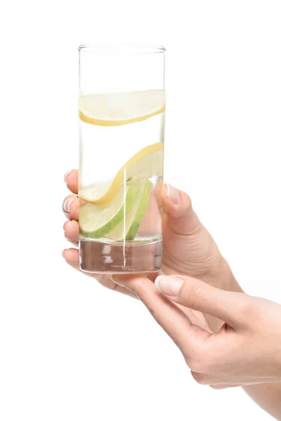 Hands holding glass of water with lemon — Stock Photo