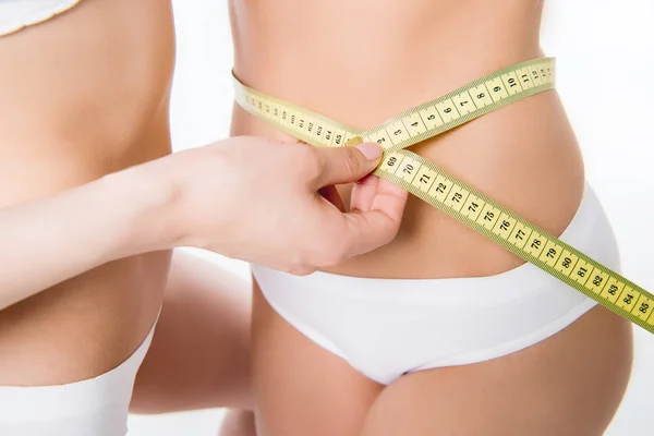 Girls using measuring tape to waist — Stock Photo