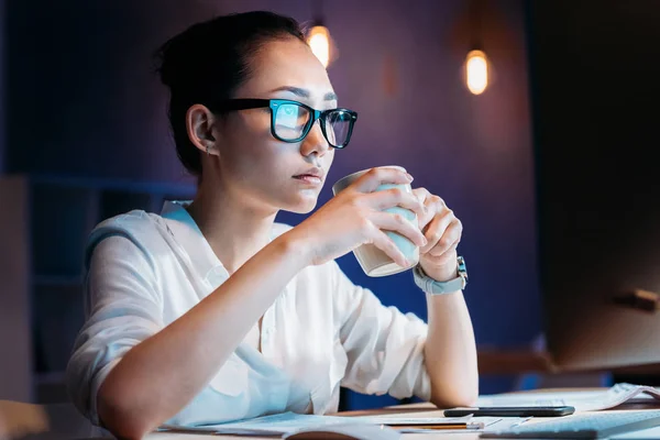 Empresaria que trabaja hasta tarde en la oficina - foto de stock