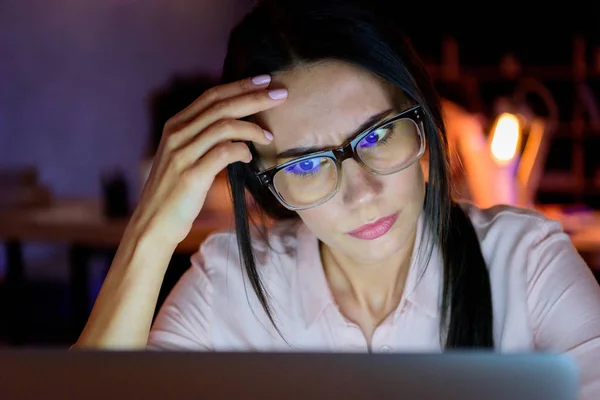 Mujer de negocios mirando en el ordenador portátil en pose reflexiva - foto de stock