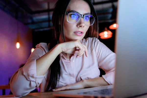 Caucasian businesswoman in glasses looking at laptop — Stock Photo
