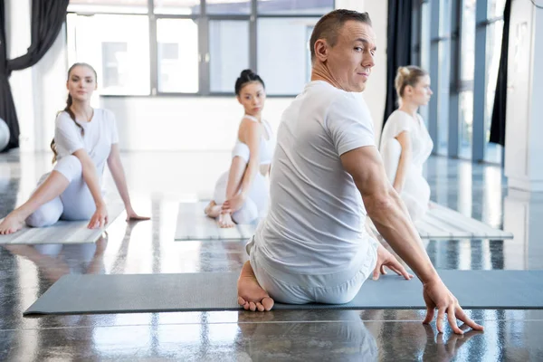Женщины, практикующие йогу с тренером — стоковое фото