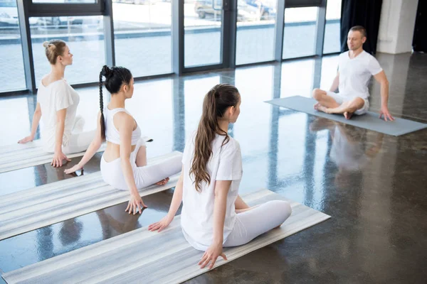 Women sitting in lotus pose with instructor — Stock Photo