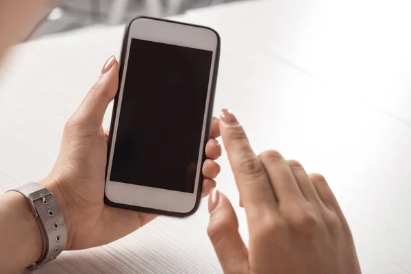 Женщина держит смартфон с пустым экраном — стоковое фото