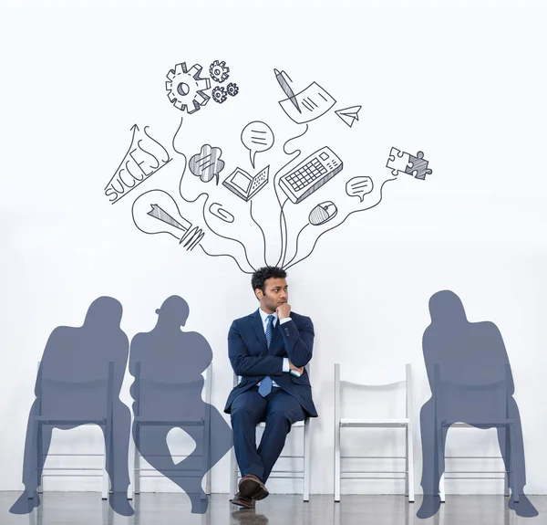 Businessman in suit sitting with shadows — Stock Photo