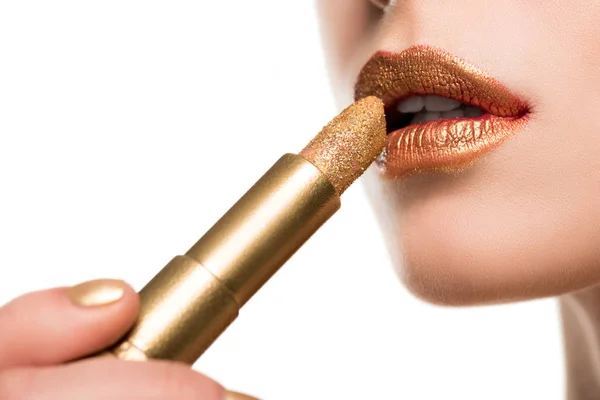 Mujer aplicando lápiz labial dorado - foto de stock