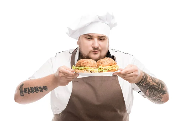 Cuisinière avec hamburgers sur plaque — Photo de stock