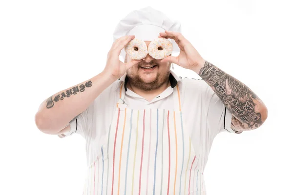 Chef covering eyes with doughnuts — Stock Photo