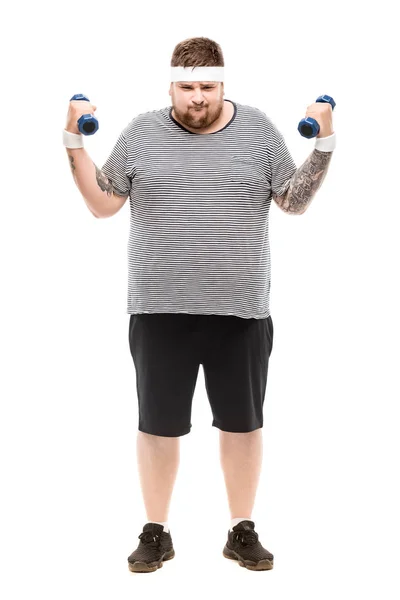 Young chubby man exercising with dumbbells — Stock Photo