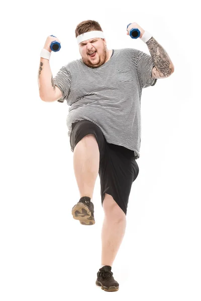 Young obese man holding dumbbells — Stock Photo