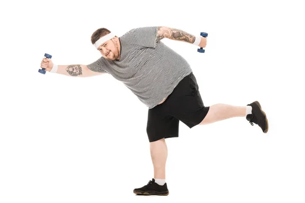 Young obese man running with dumbbells — Stock Photo