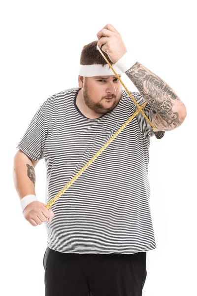 Hombre que mide el volumen del bíceps con cinta - foto de stock