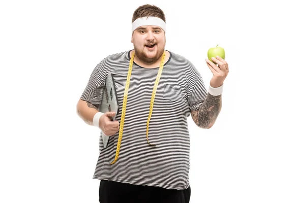 Man holding body scales and apple — Stock Photo