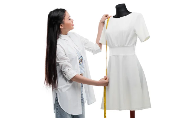 Asian dressmaker measuring dress on dummy — Stock Photo