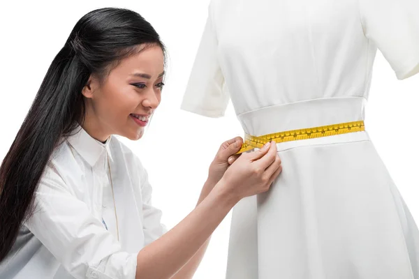 Asian dressmaker measuring dress on dummy — Stock Photo