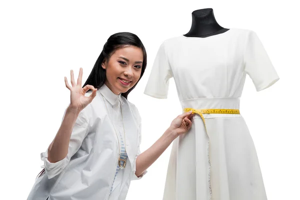 Fashion designer measuring dress on dummy — Stock Photo