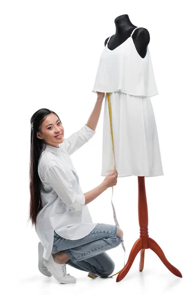 Fashion designer measuring dress on dummy — Stock Photo