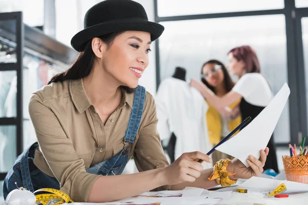 Modeschöpfer schaut sich Skizze an — Stockfoto