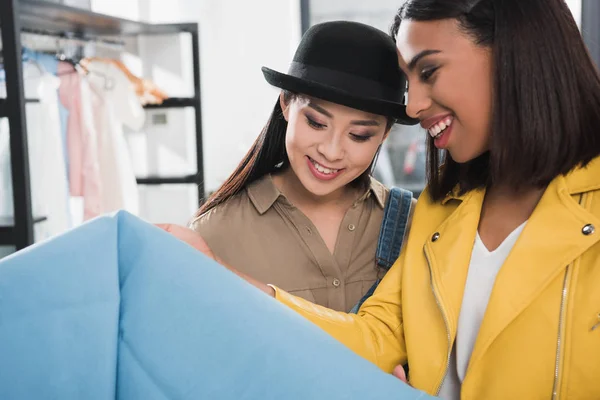 Young women choosing clothes at shop — Stock Photo