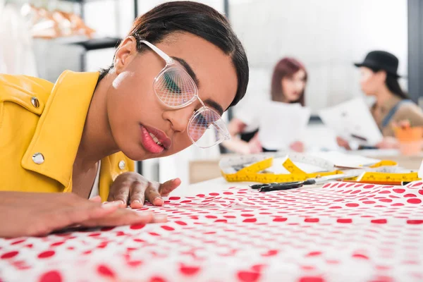 African american dressmaker fitting fabric — Stock Photo