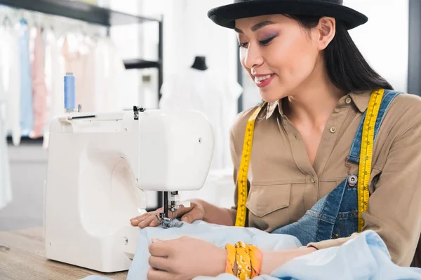 Азиатка, работающая с швейной машинкой — стоковое фото