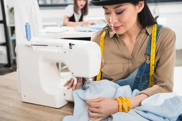 Mujer asiática trabajando con máquina de coser - foto de stock