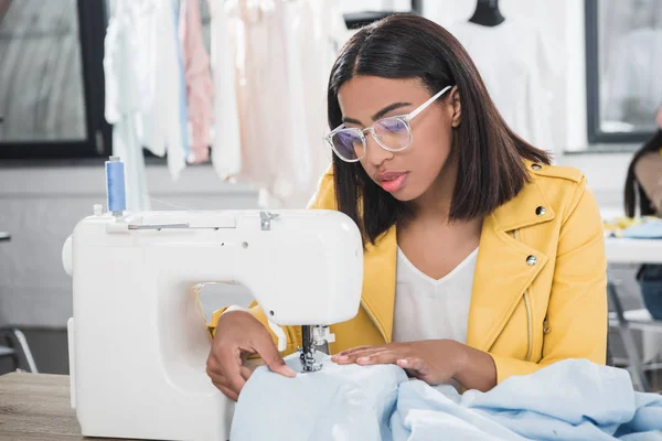 Young seamstress working with sewing machine — Stock Photo