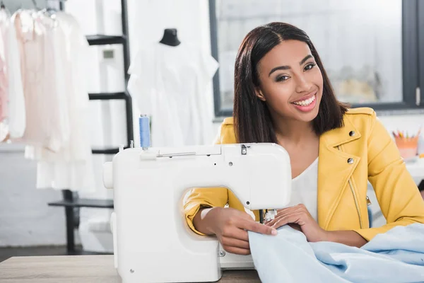 Joven costurera que trabaja con la máquina de coser - foto de stock