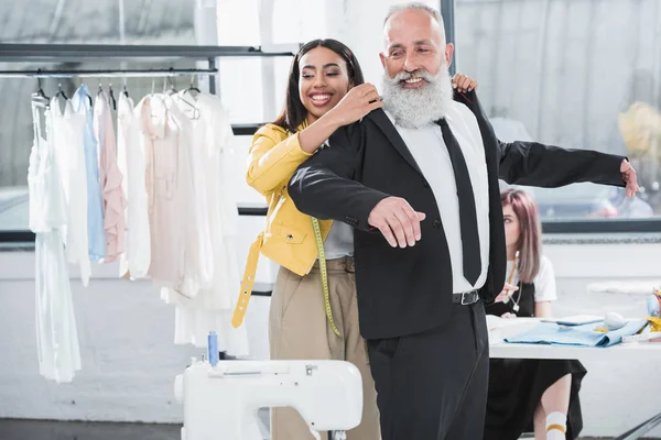 Senior man with stylist fitting suit — Stock Photo