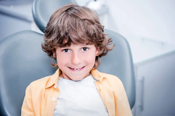 Niño sentado en silla de dentista - foto de stock