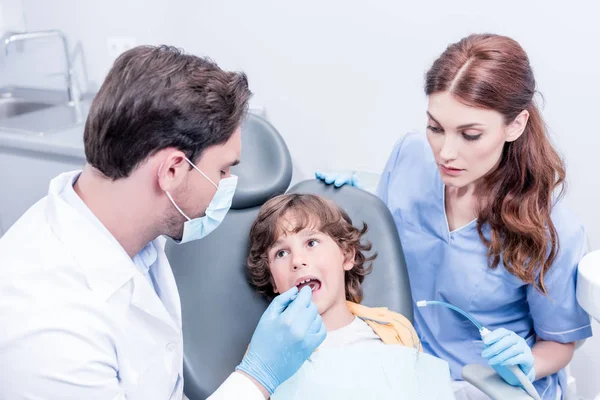 Odontólogos examinando pacientes dientes - foto de stock