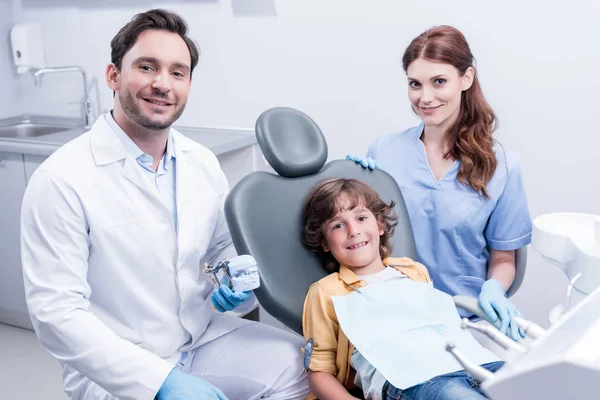 Dentistas y niño en clínica dental - foto de stock
