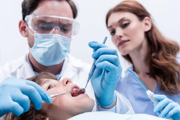 Odontólogos examinando pacientes dientes - foto de stock