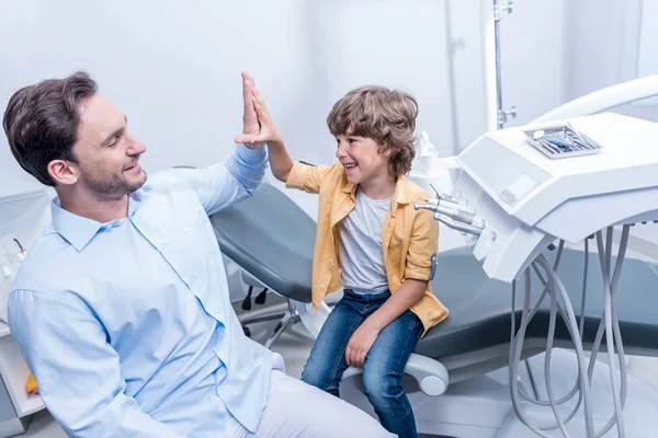 Dentist and boy in dental clinic — Stock Photo