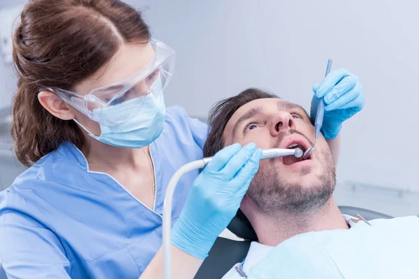Dentiste guérir les dents des patients — Photo de stock