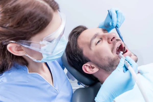 Dentista cura los dientes de los pacientes - foto de stock