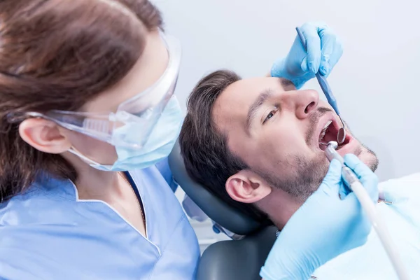 Dentiste guérir les dents des patients — Photo de stock